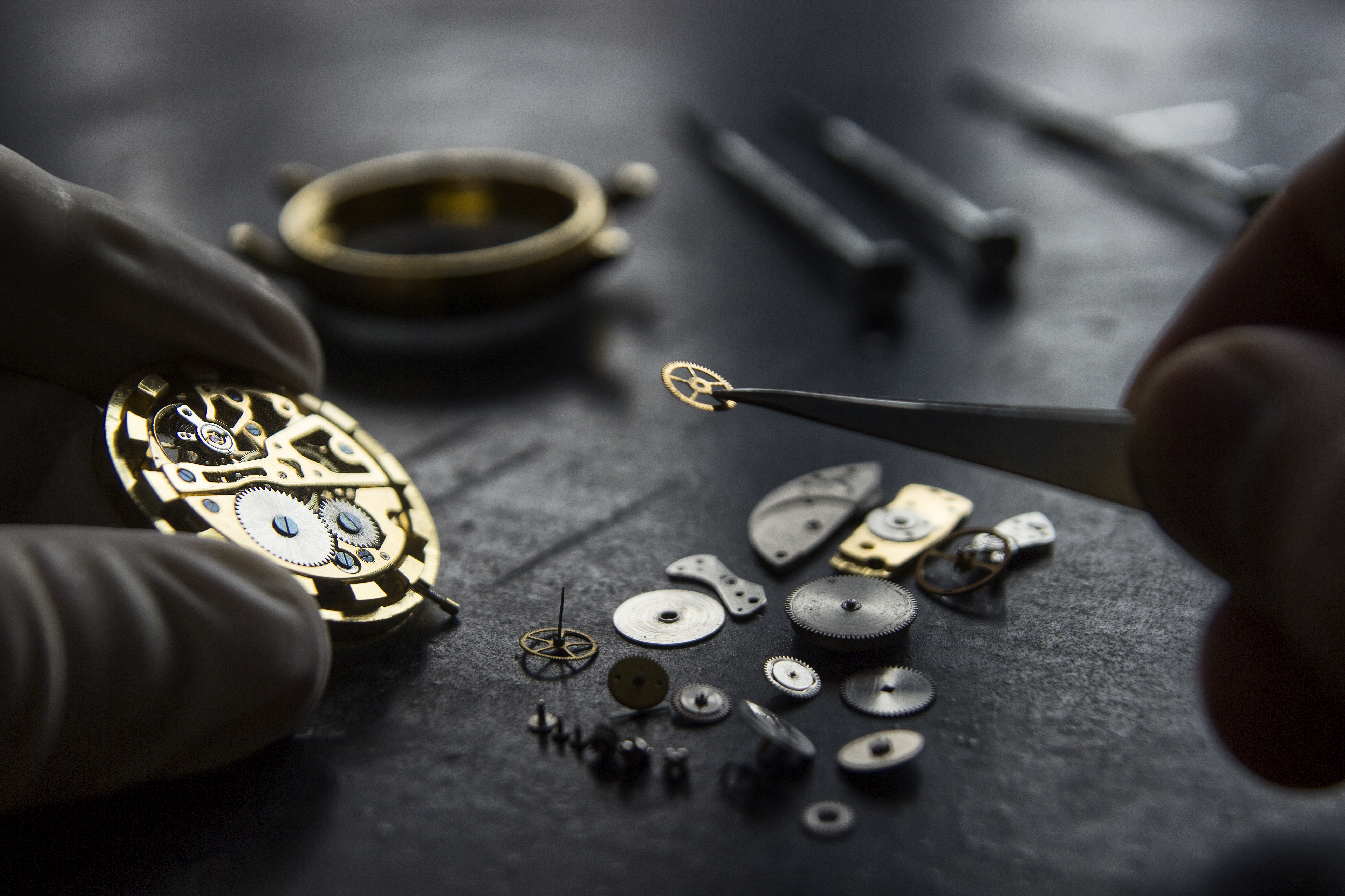 Watchmaker placing a single gear into a complex movement — precision at every layer